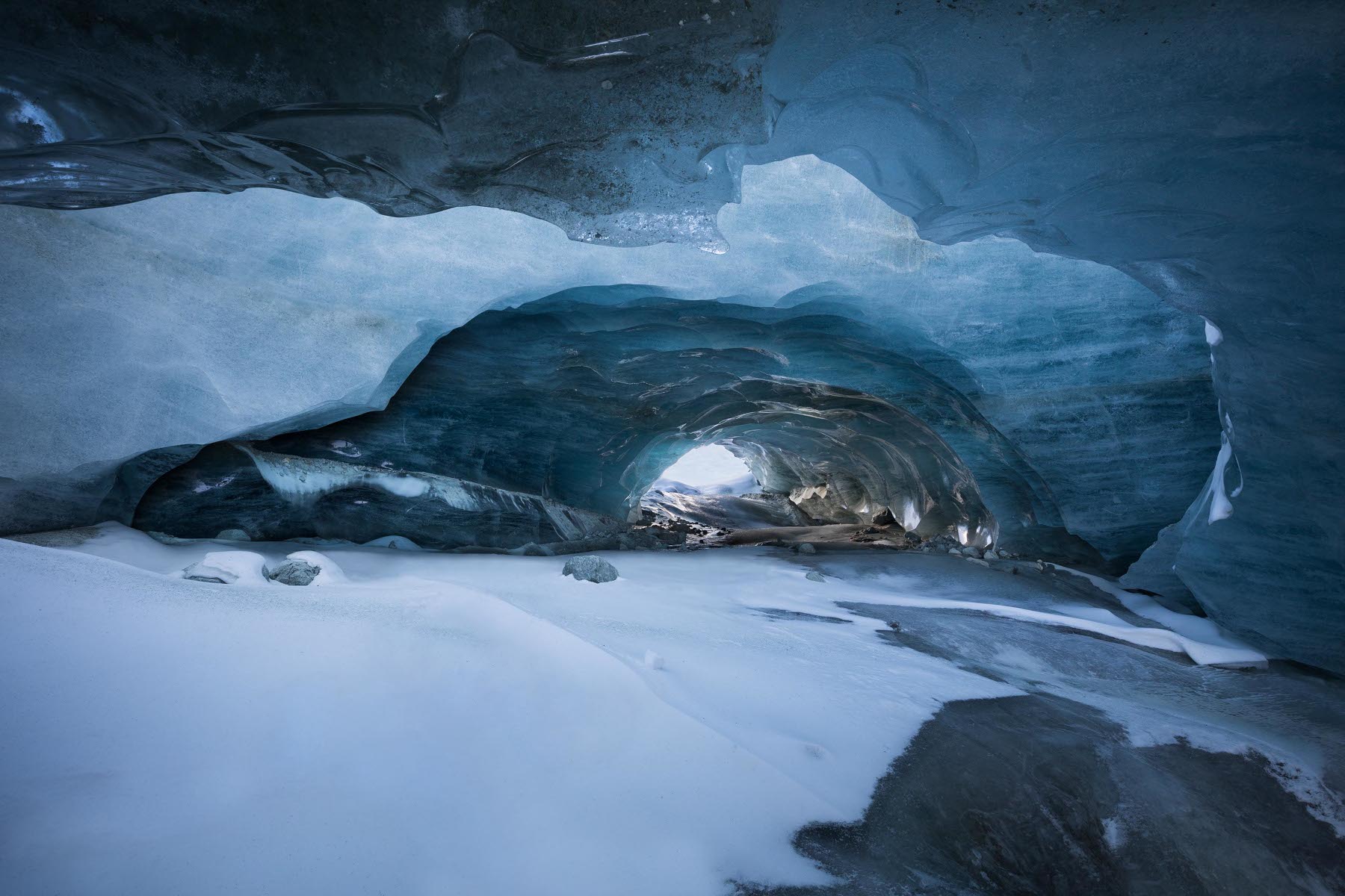 Réseau sous-glaciaire latéral par rapport à la calotte glaciaire principale. Nous sommes en rive droite du glacier. Depuis un premier tunnel, nous voyons un deuxième tunnel. La hauteur de plafond est d'environ 3m sur toute sa longueur.